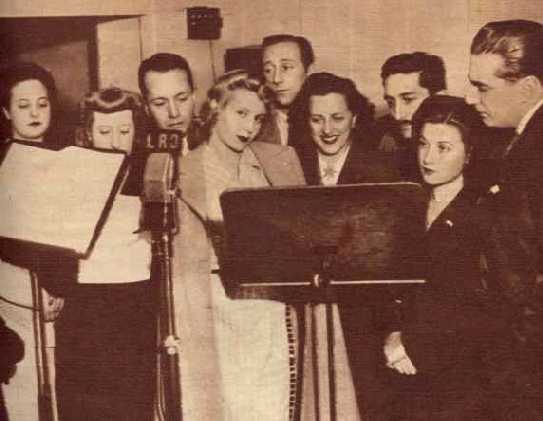 Eva Duarte ya tiene su propia compaña radial, julio de 1944, rodeada de artistas, interpretando textos de Muñoz Azpiri